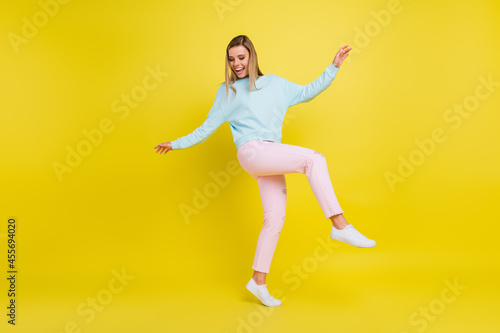 Full length body size view of attractive carefree cheerful girl moving having fun isolated over bright yellow color background