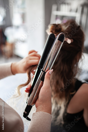 stylist hairdresser makes a hairstyle for a girl in his beauty salon, hollywood wave, beautiful hairstyle, hairdresser at work