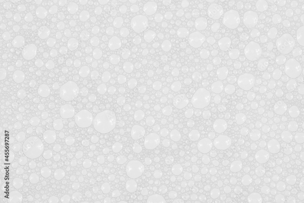 Texture of small soap bubbles on water background. foam