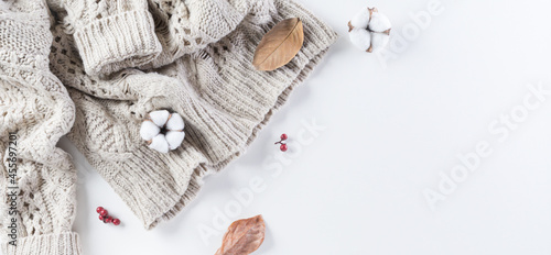 Autumn composition. Cotton flowers, autumn leaves and women sweater on white background. Flat lay, top view with copy space.