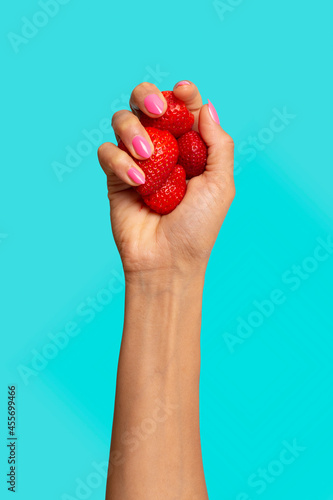Hand holding strawberries