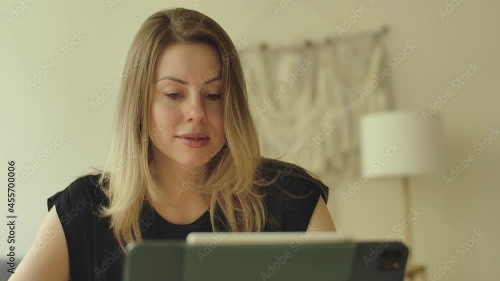 Young adult woman talks in online conference meeting. Videocall application, internet talk. Covid-19 quarantine lockdown restrictions. Female consulting communication by webcam video call with tablet. Young adult woman talks in online conference meeting. Videocall application, internet talk. Covid-19 quarantine lockdown restrictions. Female consulting communication by webcam video call with tablet.