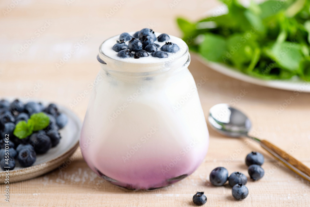 Blueberry greek yogurt in jar on wooden table, healthy food for diet and weight loss Blueberry greek yogurt in jar on wooden table, healthy food for diet and weight loss
