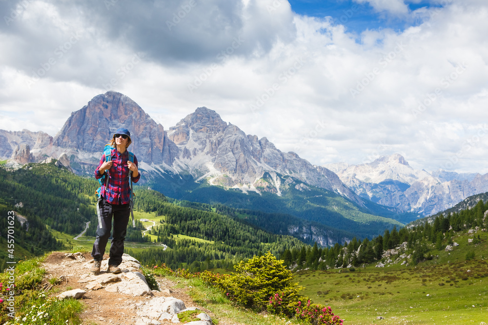 Woman traveler with breathtaking landscape of Dolomites Mounatains in summer, Italy. Travel Lifestyle wanderlust adventure concept