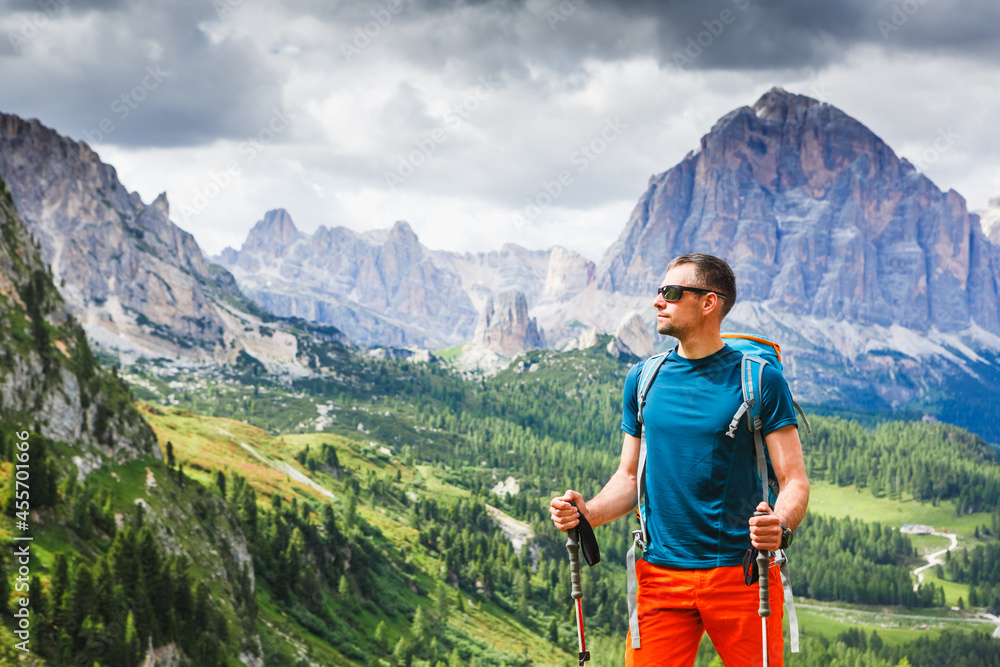 Young man with backpack on a mountain trail, Dolomites Mountains, Italy