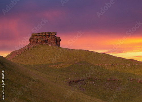 Chest butte of the Sunduki mountain range located in the valley of the Bely Iyus River in Khakassia, Russia. Perfect landscape under colorful awe sky in summer evening steppe