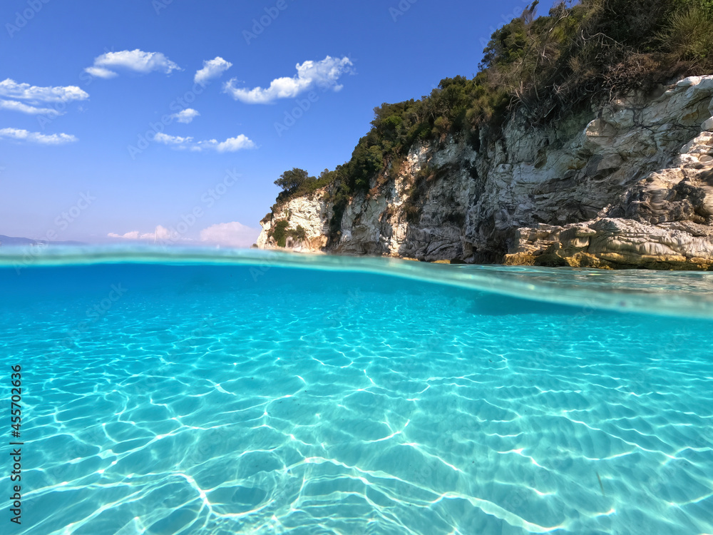 Underwater sea level split photo of beautiful paradise turquoise exotic island beach in Caribbean island destination