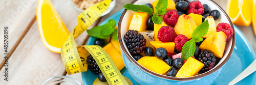 Concept of low calories delicious desserts. Summer fresh bowl with colorful fruit salad. Healthy natural organic food. Tasty sweet snack  light simple tasty lunch. Close up  wooden background banner