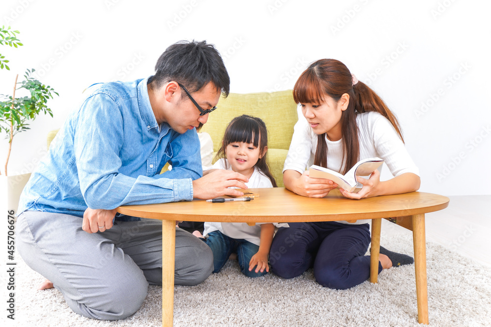 子どもに教育をする両親