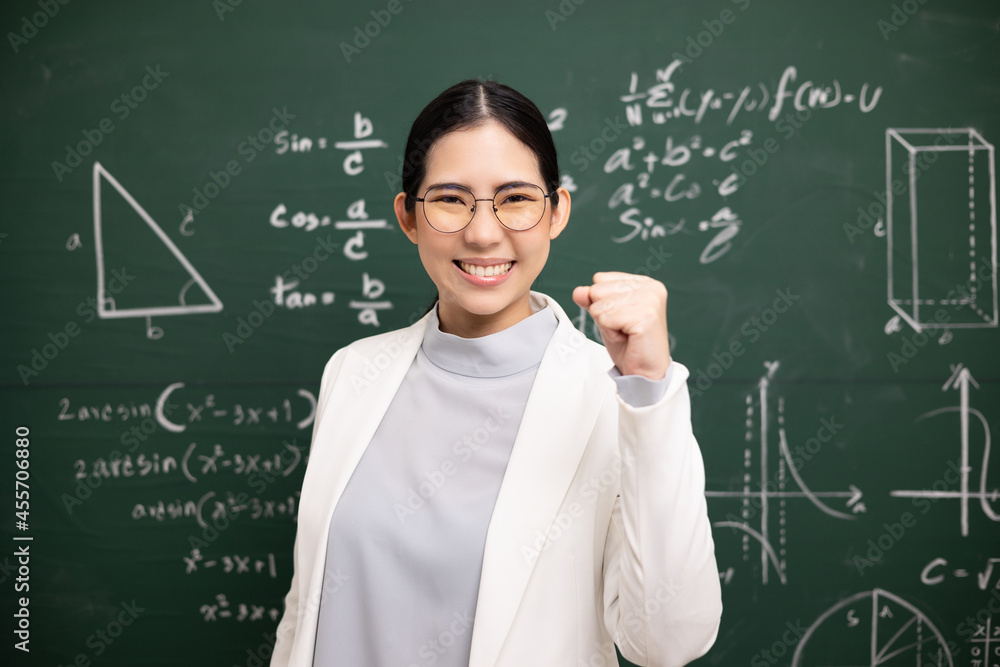 Happy Young asian teacher woman showing fist fighting sign video conference with student looking camera. Female teacher training the mathematics in classroom blackboard online course.