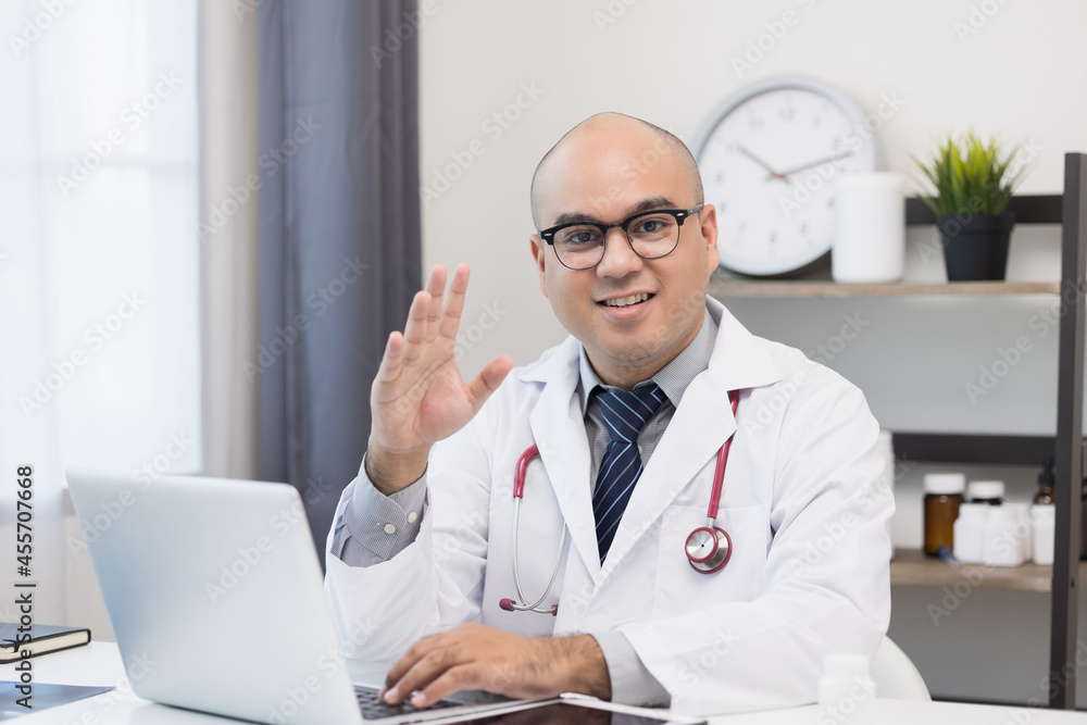 Young asian man doctor works from home working online looking and camera talking with patient Explain about taking medications to treat illnesses. Young asian man doctor works from home working online looking and camera talking with patient Explain about taking medications to treat illnesses.
