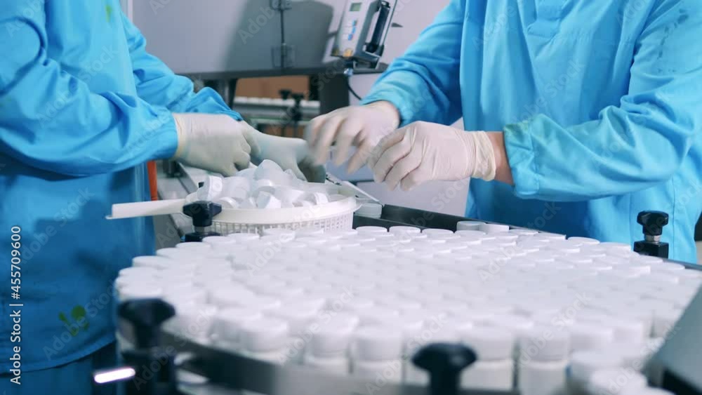 Factory workers are closing tubs with pills Factory workers are closing tubs with pills