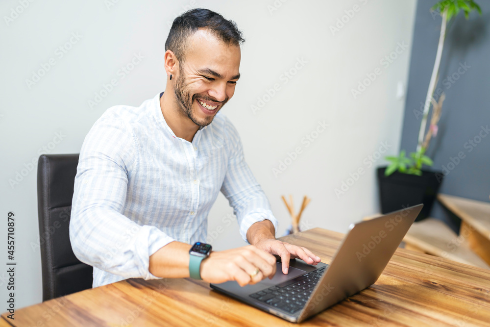 Portrait young mexican attractive businessman working at modern home office with computer laptop Portrait young mexican attractive businessman working at modern home office with computer laptop
