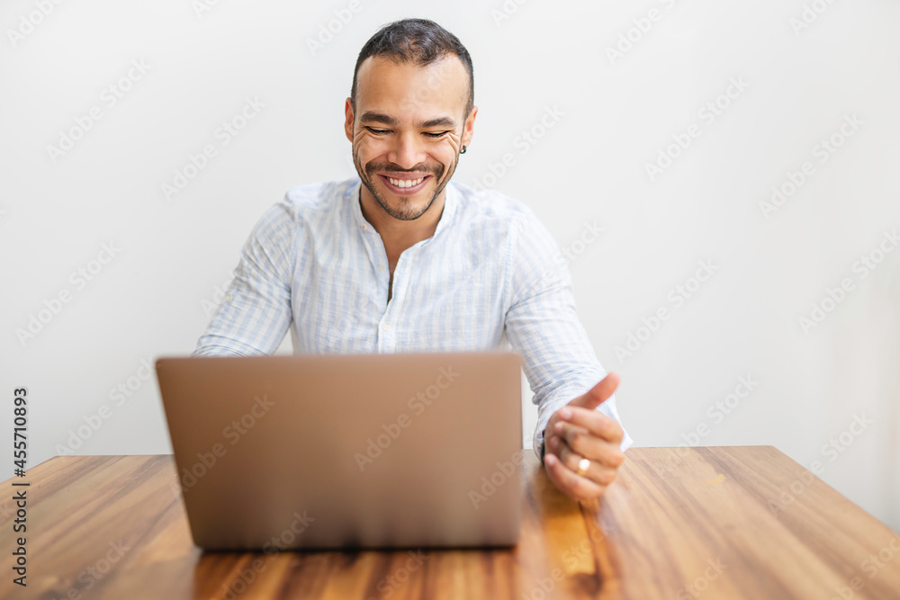 Portrait young mexican attractive businessman working at modern home office with computer laptop Portrait young mexican attractive businessman working at modern home office with computer laptop