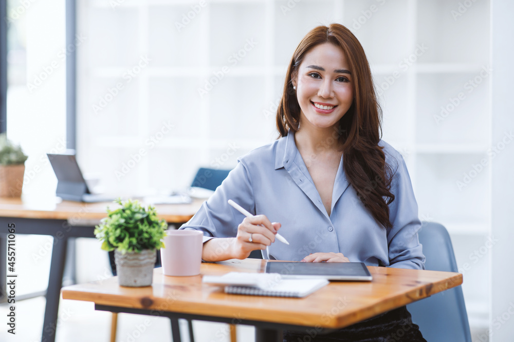 Portrait of smiling beautiful business asian woman with working in modern office desk using computer, Business people employee freelance online marketing e-commerce telemarketing concept. Portrait of smiling beautiful business asian woman with working in modern office desk using computer, Business people employee freelance online marketing e-commerce telemarketing concept.
