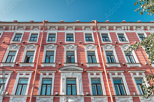 Typical building facade pink and white color with windows in Saint-Petersburg on sunny day, Russia