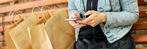 Banner of Woman sitting on the bench in the park withpaper shopping bags after shopping