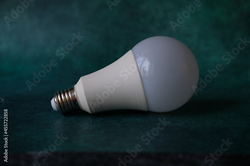 LED white lightbulb lamp on the emerald background. Front view
