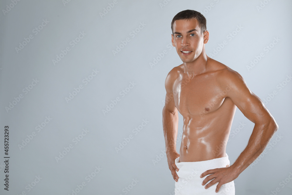 Healthy man wrapping a towel around his waist leaving his upper