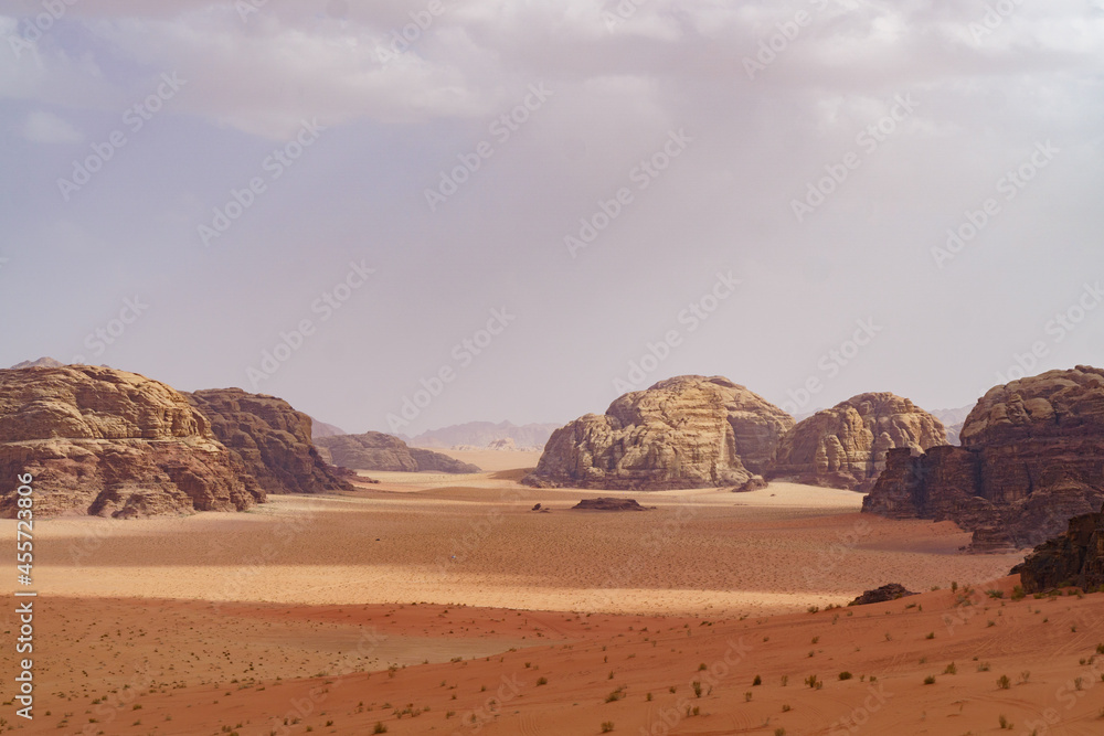 Wadi Rum desert, Jordan. The Valley of the Moon. Red sand, mountains and haze. Designation as a UNESCO World Heritage Site. National park outdoors landscape. Offroad adventures travel background.
