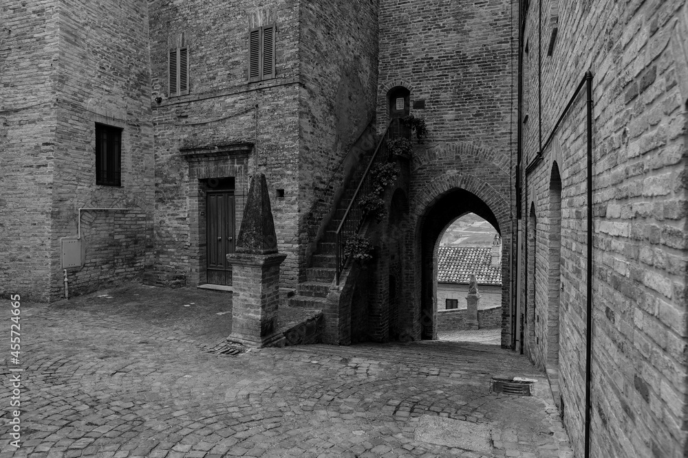 Glimpse of a small medieval village in the province of Fermo, in the background the Marche countryside, very cloudy sky, black and white photo. Glimpse of a small medieval village in the province of Fermo, in the background the Marche countryside, very cloudy sky, black and white photo.