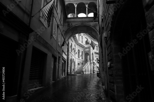 View of the medieval village of Fermo (Marche Italy), Palazzo dei Priori, rain-soaked paving, black and white photo.