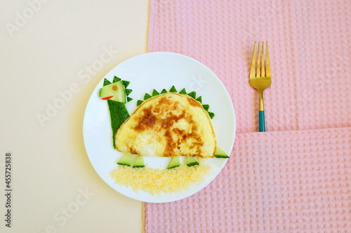 Dinosaur made of eggs and vegetables. Food art. Funny idea of breakfast. Creative dish. Snack time for Kids. 