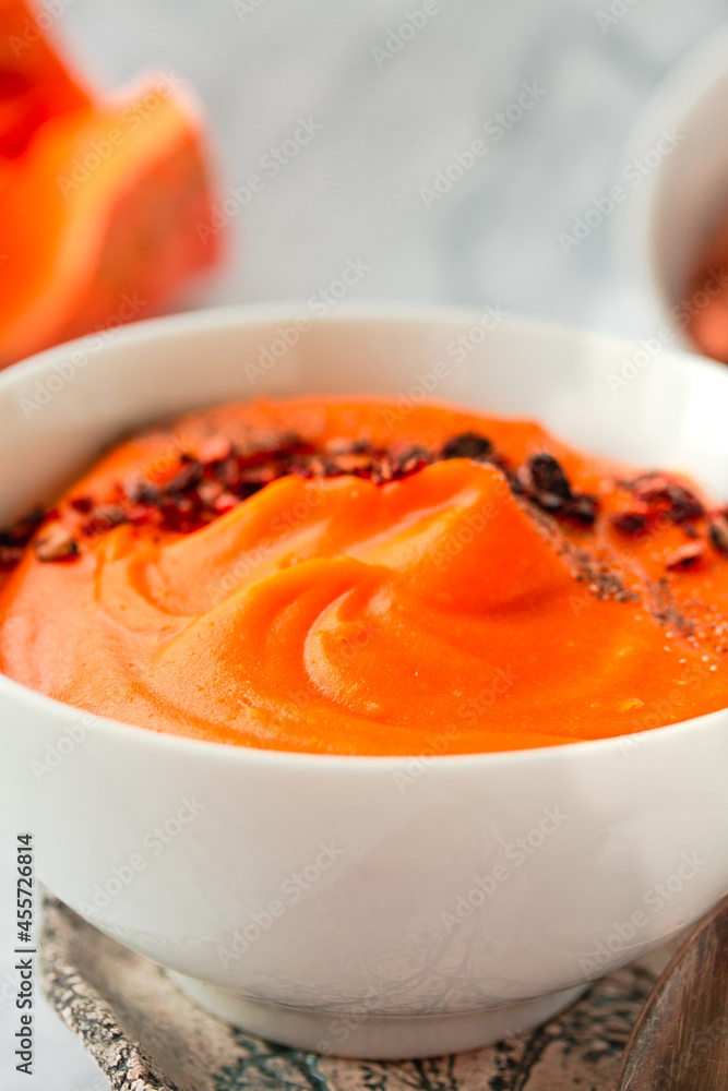 Pumpkin soup with black and chili flakes pepper, rye crispy toast on marble background.Traditional fall and winter dishes. Dietary vegetable food concept.Close-up Pumpkin soup with black and chili flakes pepper, rye crispy toast on marble background.Traditional fall and winter dishes. Dietary vegetable food concept.Close-up