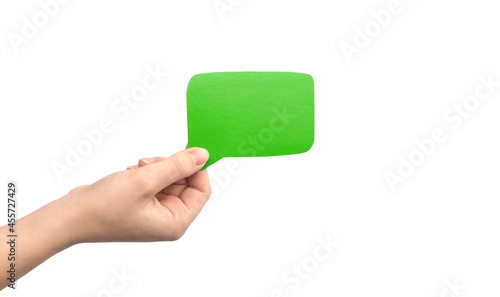 Green speech bubble in hand isolated on a white background. Giving feedback, communication concept. Empty cardboard text box mockup