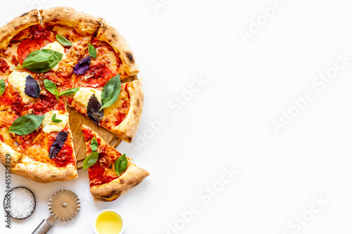 Cut into slices italian pizza with tomatoes cheese and basil
