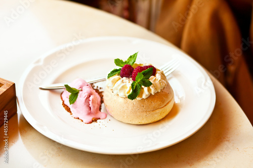 Pavlova meringue mini cake with fresh berries on cafe table