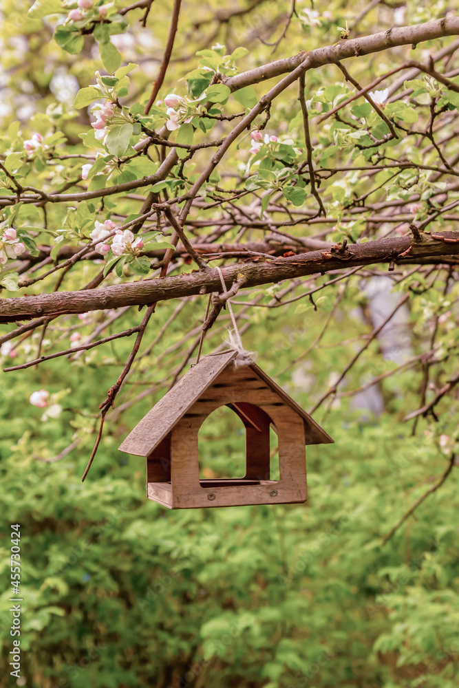 wooden birdhouse hanging in a blooming apple orchard wooden birdhouse hanging in a blooming apple orchard