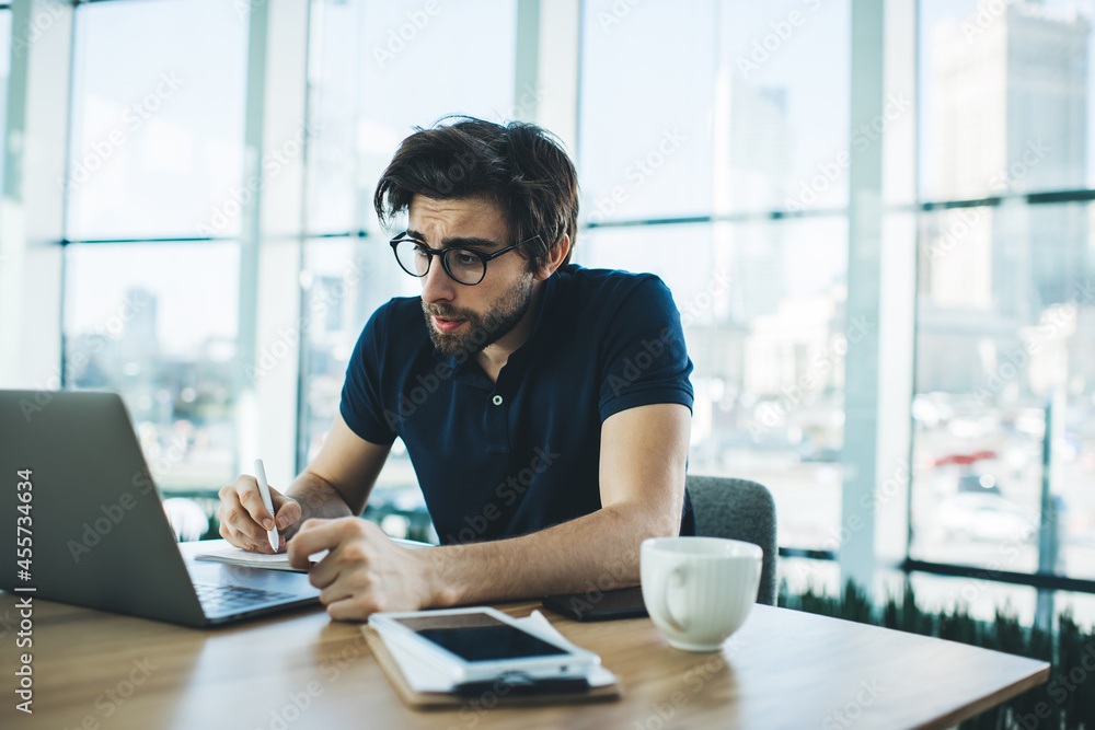 Thoughtful ethnic man with laptop in workspace Thoughtful ethnic man with laptop in workspace