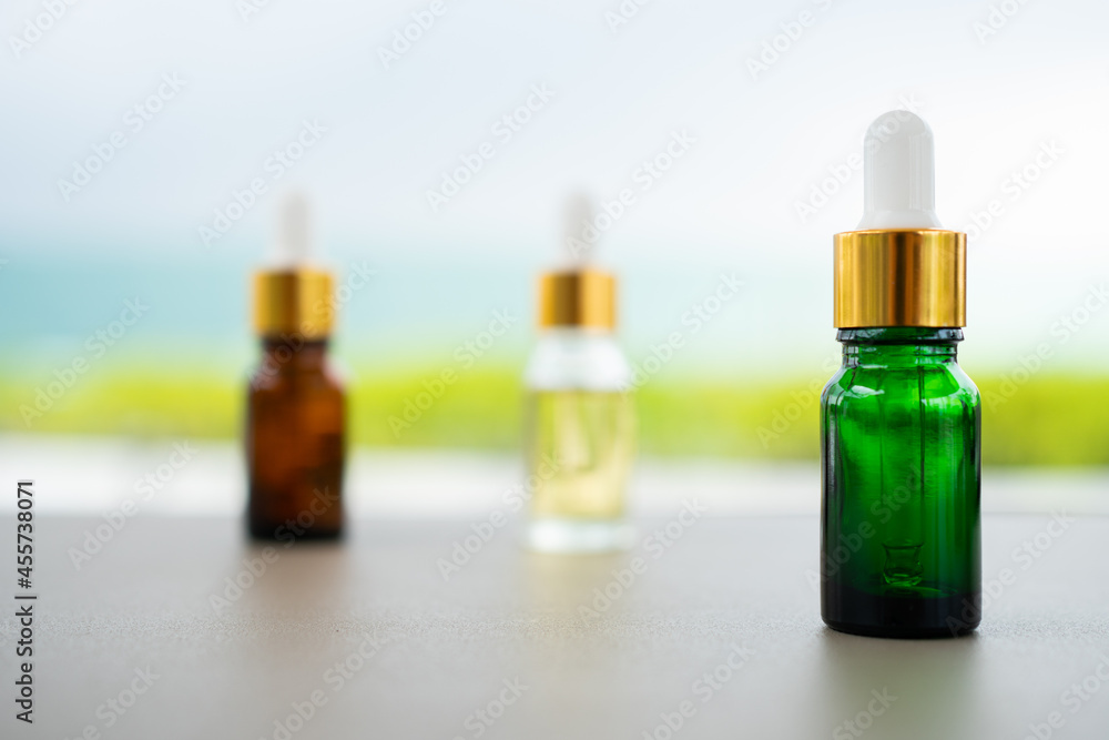 Set of multi color glass bottles with dropper on the table. Concept of aroma oil, cosmetic and beauty skin. Set of multi color glass bottles with dropper on the table. Concept of aroma oil, cosmetic and beauty skin.
