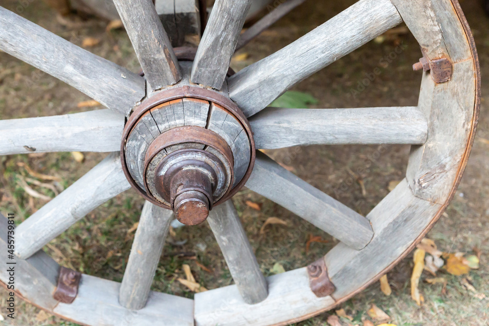 wooden van wheel, gray and weathered traditional close-up on ground background