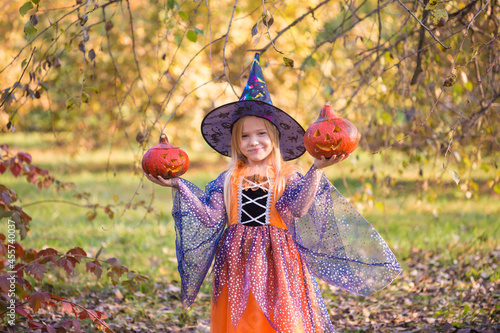 Girl in fabulous dress witch  forest  pumpkin