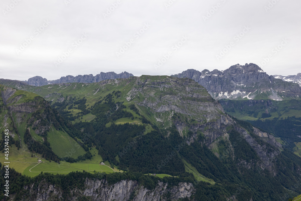Naklejka premium Amazing hiking day in the hearth of Switzerland. Wonderful scenery while climbing the summit and watching over the alps. Epic landscape.