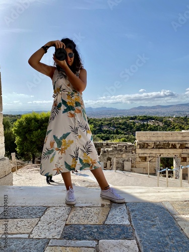 Photographer women in a white and yellow dress in Acropolis of Athens, Greece photo
