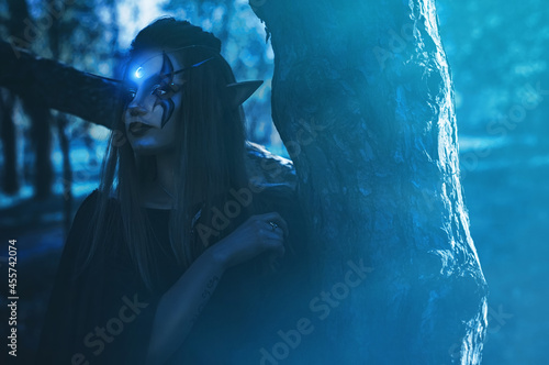 Woman in Elf cosplay near trees photo