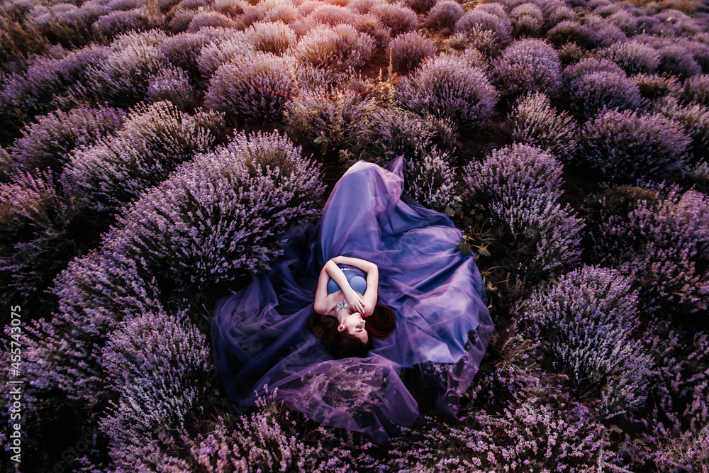 © Scopio - Woman wearing long lilac dress lying in lavender field © Scopio - Woman wearing long lilac dress lying in lavender field