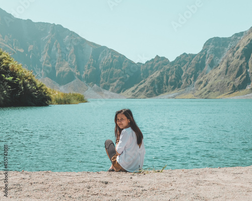 Woman wearing light top sitting by waterside photo