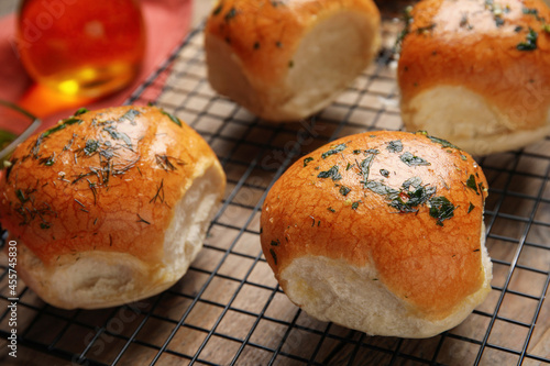 Traditional Ukrainian bread (Pampushky) with garlic on baking grid, closeup photo