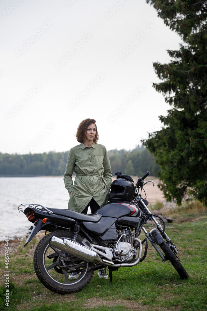 girl riding a motorcycle outdoors. Portrait of a confident woman on a beach background girl riding a motorcycle outdoors. Portrait of a confident woman on a beach background