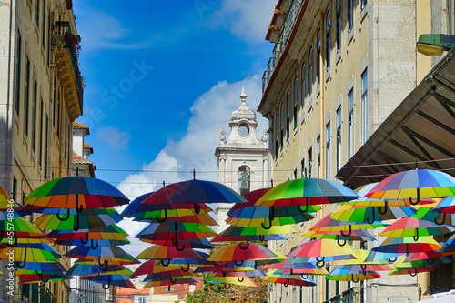 Colored umbrellas between buildings in the pink street of Lisbon (Portugal)