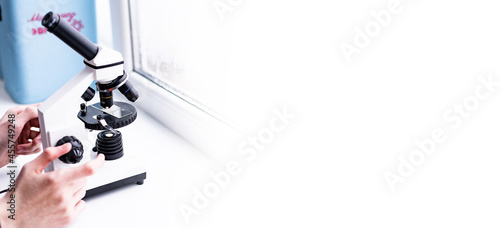 A white microscope on the table, a scientific laboratory. Laboratory of Medical Sciences. Look through a microscope, analyze the test sample. the field of biotechnology, work on advanced equipment