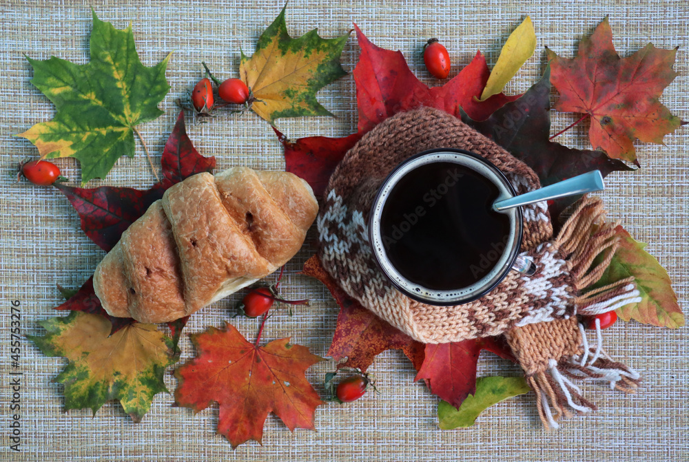 Cup of coffee and croissant isolated in autumn decoration background. Autumn still life. Top view food. Cup of coffee and croissant isolated in autumn decoration background. Autumn still life. Top view food.