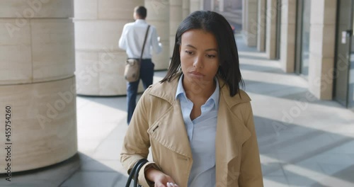 Slider shot of tired and sad businesswoman walking outside office building