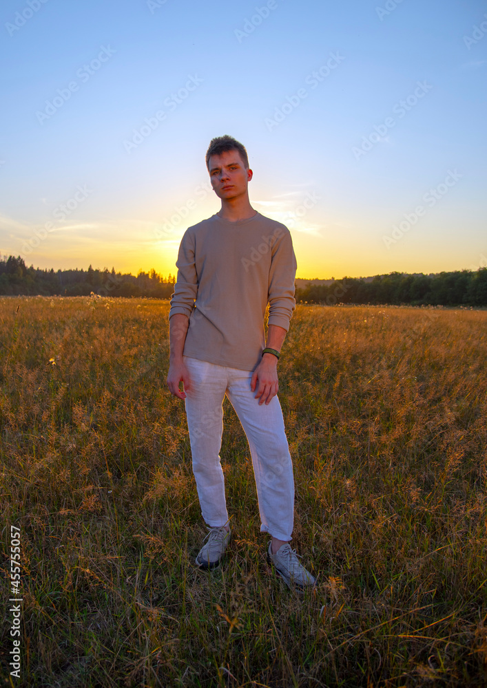 Portrait of a young man standing in a field .