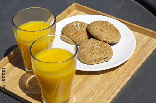 two crystal glasses of orange juice and breads