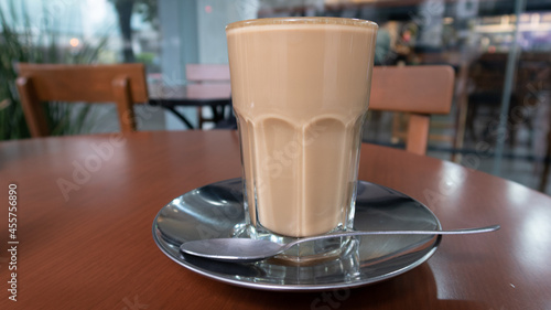 vaso de café con leche (lechero) tradicional de Veracruz México sobre plato de metal con cuchara